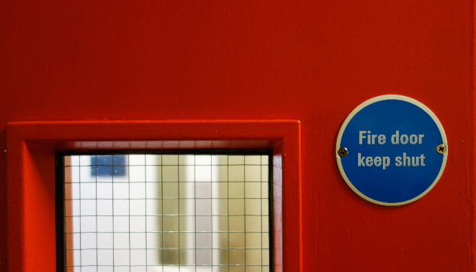 An up close image of a red fire exit door.