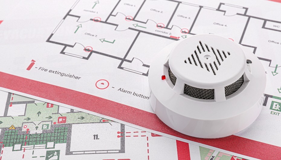 Fire alarm sat on top of a building's fire evacuation plan.